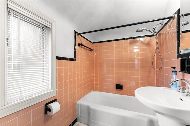 full bath featuring a sink, tile walls, and bathing tub / shower combination