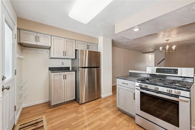 510 Brinton Ave, Pitcairn, PA 15140 - kitchen featuring baseboards, an inviting chandelier, dark countertops, appliances with stainless steel finishes, and light wood-style flooring