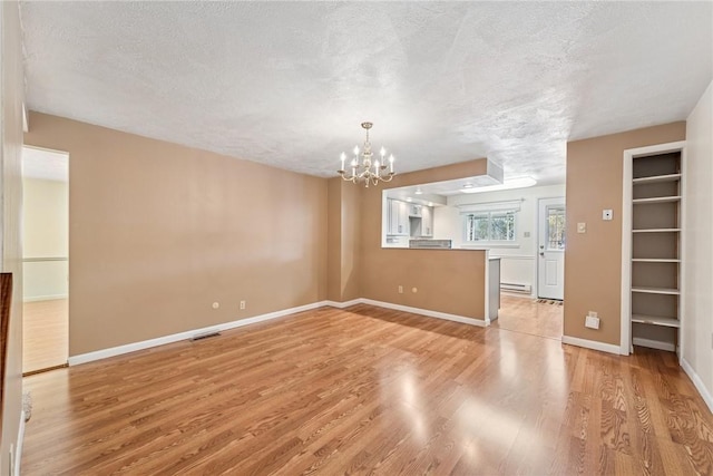 510 Brinton Ave, Pitcairn, PA 15140 - unfurnished living room featuring visible vents, baseboards, light wood-type flooring, a chandelier, and a textured ceiling