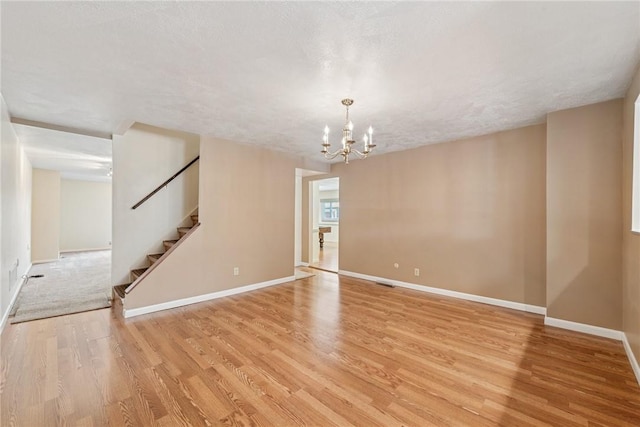 510 Brinton Ave, Pitcairn, PA 15140 - unfurnished room with light wood-style floors, visible vents, stairway, a notable chandelier, and baseboards