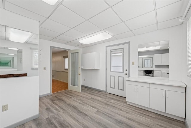510 Brinton Ave, Pitcairn, PA 15140 - kitchen featuring light wood finished floors, a paneled ceiling, white cabinetry, and light countertops