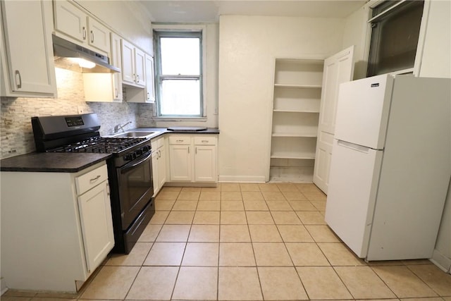 7807 Kelly St, East Hills, PA 15208 - kitchen with freestanding refrigerator, tasteful backsplash, under cabinet range hood, gas stove, and dark countertops
