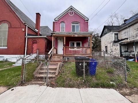 7807 Kelly St, East Hills, PA 15208 - view of front of home with a fenced front yard, a chimney, a gate, and covered porch