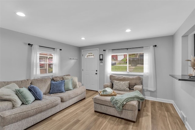 living room with light wood-type flooring, baseboards, visible vents, and recessed lighting