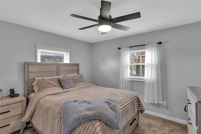 bedroom with light carpet, multiple windows, baseboards, and ceiling fan