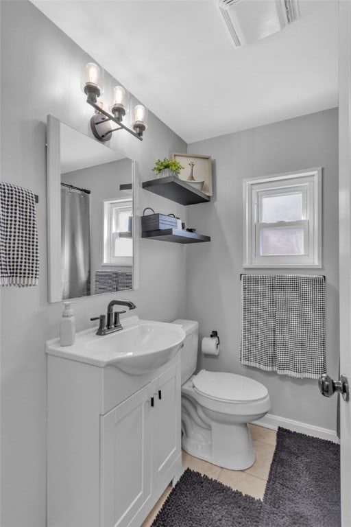 full bath featuring toilet, vanity, tile patterned flooring, and plenty of natural light