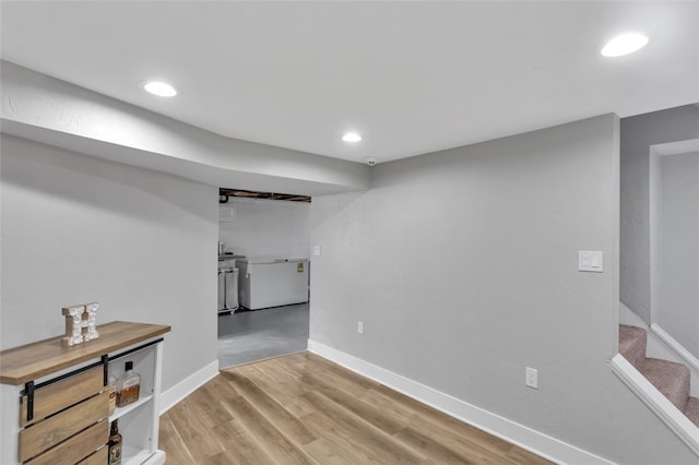 finished basement with wood finished floors, baseboards, stairs, and recessed lighting