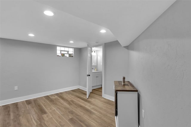 below grade area featuring baseboards, light wood-type flooring, and recessed lighting