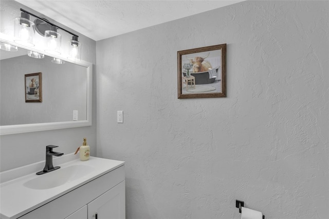 bathroom with a textured wall and vanity