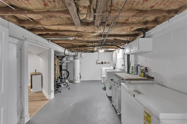 unfinished below grade area with water heater, separate washer and dryer, and refrigerator