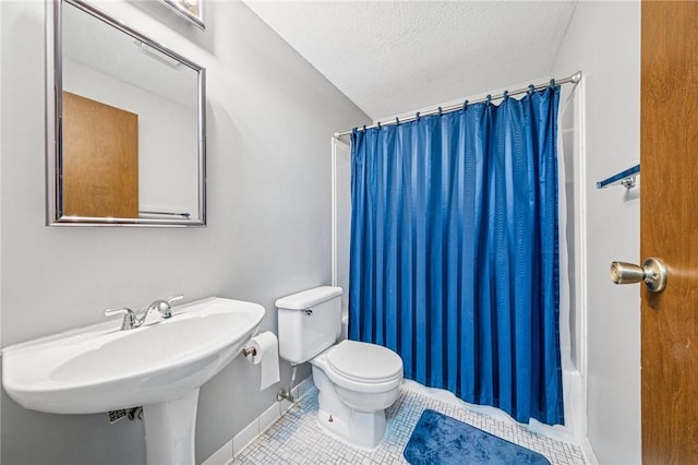bathroom featuring a shower with shower curtain, tile patterned floors, a textured ceiling, and toilet
