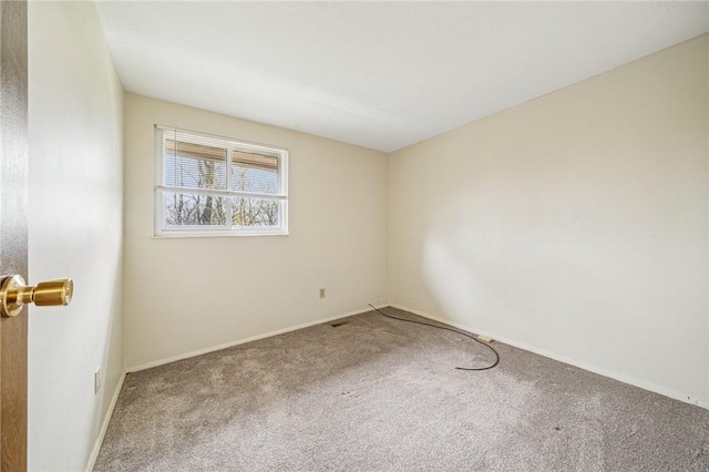 spare room featuring carpet flooring and baseboards