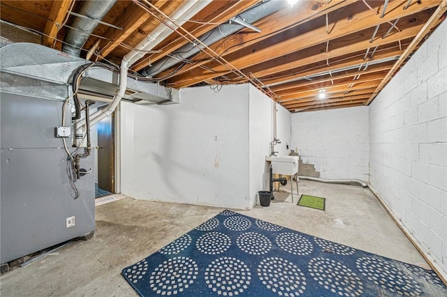 unfinished below grade area with a sink and heating unit