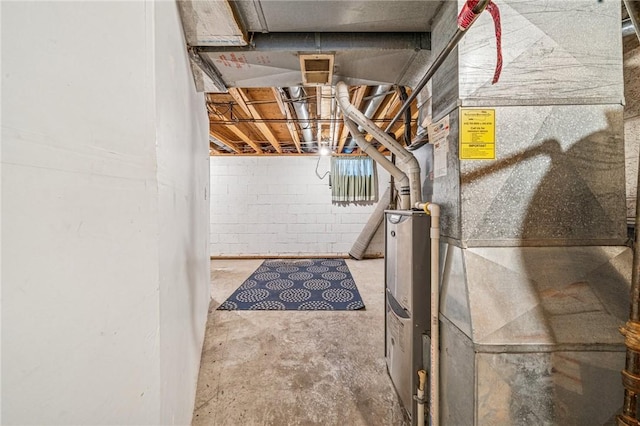 unfinished below grade area featuring concrete block wall and heating unit