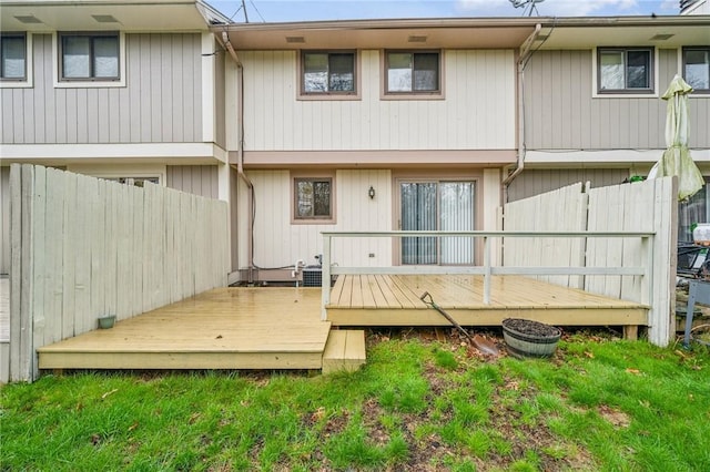 rear view of property featuring a wooden deck and fence
