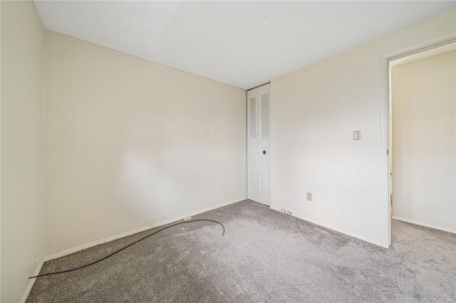 empty room with baseboards and carpet flooring