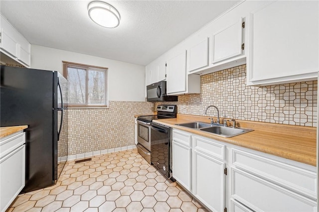 kitchen with light countertops, white cabinets, a sink, and black appliances