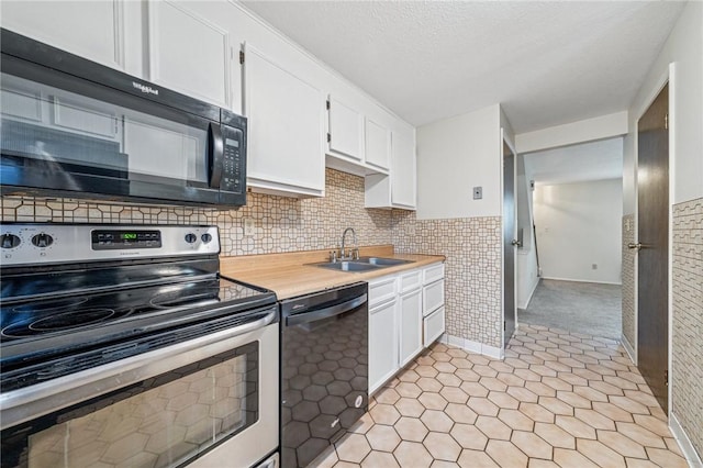 kitchen with light countertops, a sink, white cabinetry, and black appliances