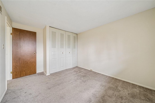 unfurnished bedroom with carpet floors, baseboards, and a closet