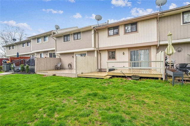 back of house featuring fence, a deck, a lawn, and cooling unit