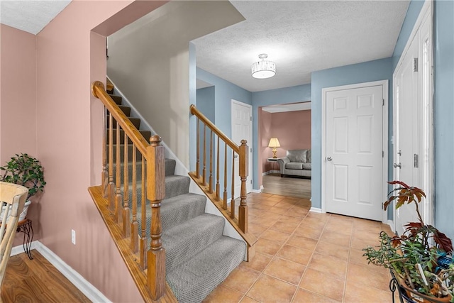 951 Castlegate Cir, Hempfield Twp, PA 15601 - entrance foyer with stairs, a textured ceiling, and light tile patterned floors