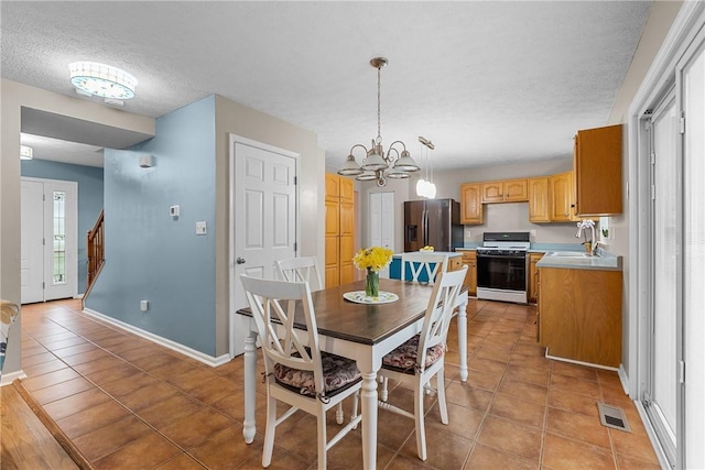 951 Castlegate Cir, Hempfield Twp, PA 15601 - dining room with a textured ceiling, a chandelier, light tile patterned floors, and stairway