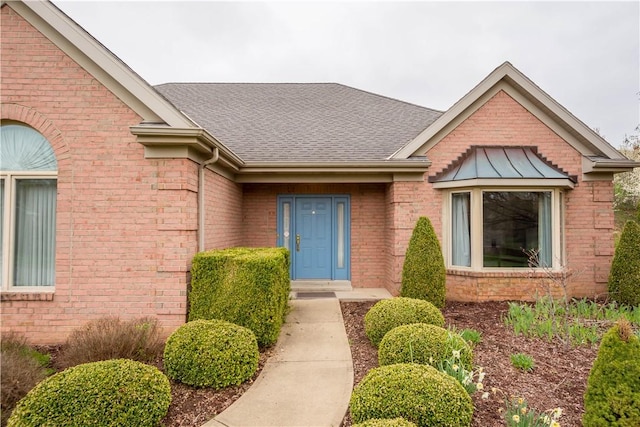 property entrance with brick siding and a shingled roof