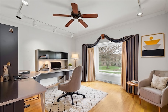 office featuring visible vents, ornamental molding, ceiling fan, light wood-type flooring, and rail lighting
