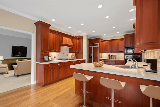 kitchen with ornamental molding, paneled fridge, a peninsula, and oven