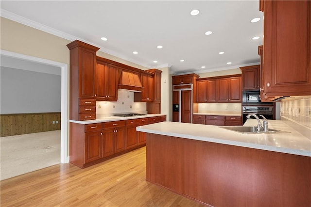 kitchen with crown molding, a peninsula, black appliances, light countertops, and a sink