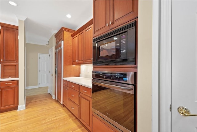 kitchen with built in appliances, light countertops, crown molding, brown cabinetry, and light wood-style flooring