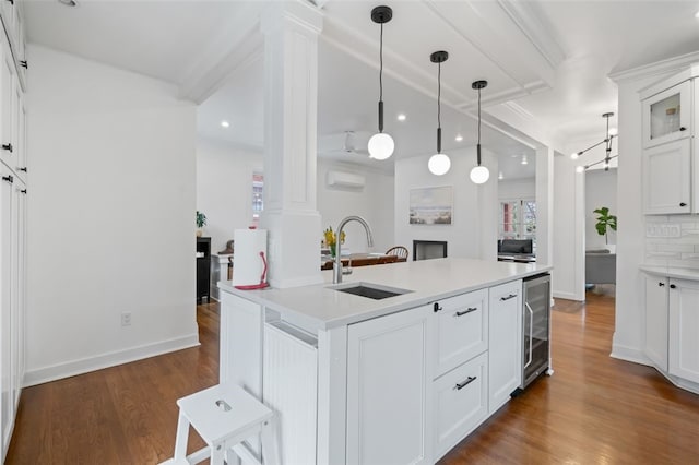 6649 Kinsman Rd, Squirrel Hill, PA 15217 - kitchen with dark wood-style floors, decorative columns, a sink, and beverage cooler
