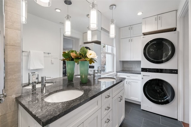 6649 Kinsman Rd, Squirrel Hill, PA 15217 - clothes washing area featuring stacked washer / dryer, laundry area, a sink, and dark tile patterned floors