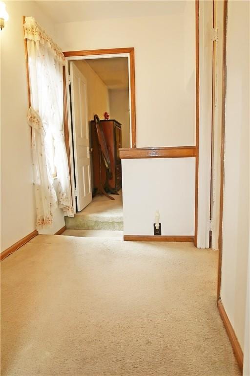 unfurnished room with light colored carpet and baseboards