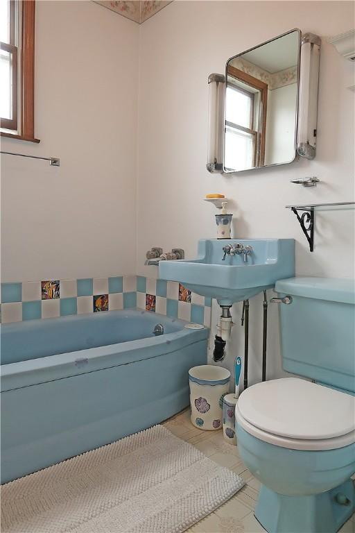 bathroom with tile patterned floors, toilet, and a bathtub