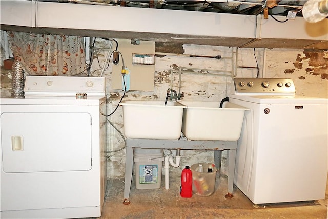 clothes washing area with a sink, washer and dryer, and laundry area