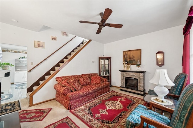 living room with a fireplace, stairway, a ceiling fan, and carpet floors