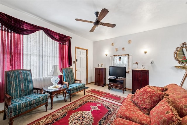 living room featuring baseboards, a ceiling fan, and carpet