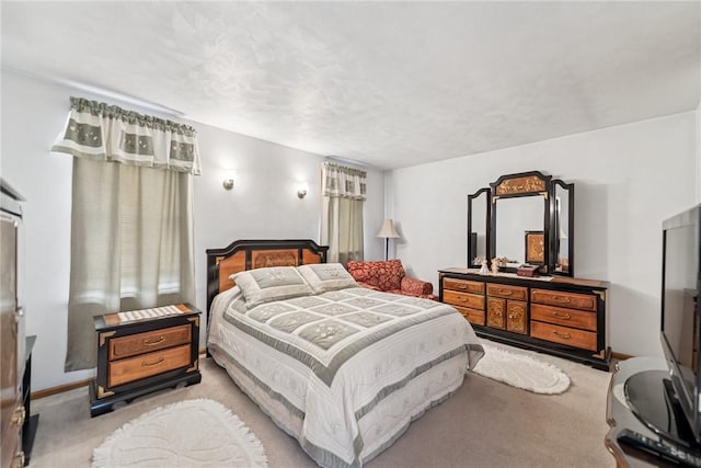 bedroom with baseboards and light colored carpet