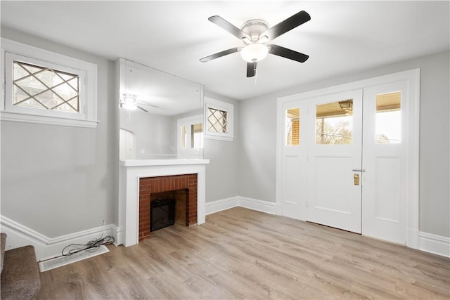 unfurnished living room featuring a wealth of natural light, a fireplace, and baseboards
