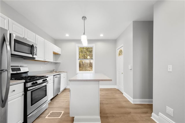 kitchen with light wood-type flooring, white cabinets, visible vents, light countertops, and stainless steel appliances