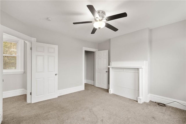 unfurnished bedroom with light colored carpet, baseboards, and a ceiling fan
