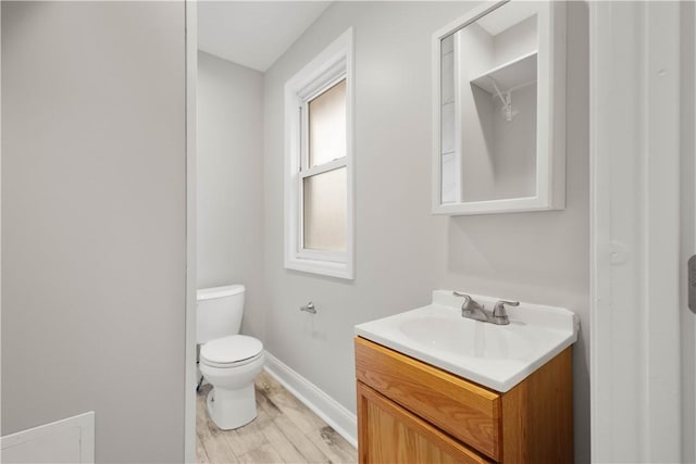 bathroom featuring vanity, baseboards, toilet, and wood finished floors
