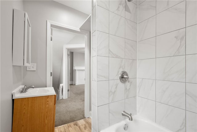 full bath with wood finished floors, vanity, and shower / washtub combination