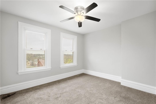 spare room with carpet, baseboards, and a ceiling fan