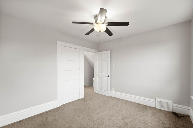 unfurnished bedroom with carpet flooring, baseboards, a ceiling fan, and visible vents