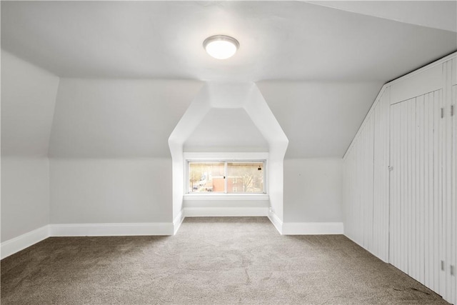 additional living space featuring baseboards, carpet flooring, and lofted ceiling