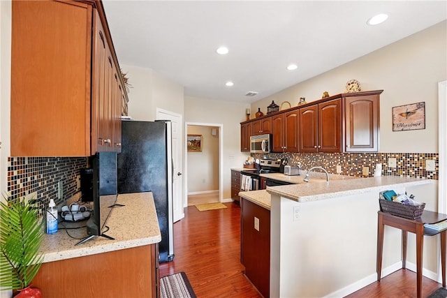 105 Hillcrest Rd, Penn Twp But, PA 16053 - kitchen featuring appliances with stainless steel finishes, a peninsula, decorative backsplash, dark wood-style flooring, and recessed lighting