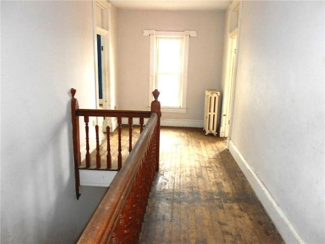 198 W Pearl St, City Of But Nw, PA 16001 - hallway featuring baseboards, radiator heating unit, wood-type flooring, and an upstairs landing
