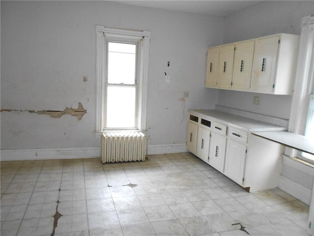 198 W Pearl St, City Of But Nw, PA 16001 - kitchen featuring radiator heating unit, light countertops, white cabinetry, and light floors